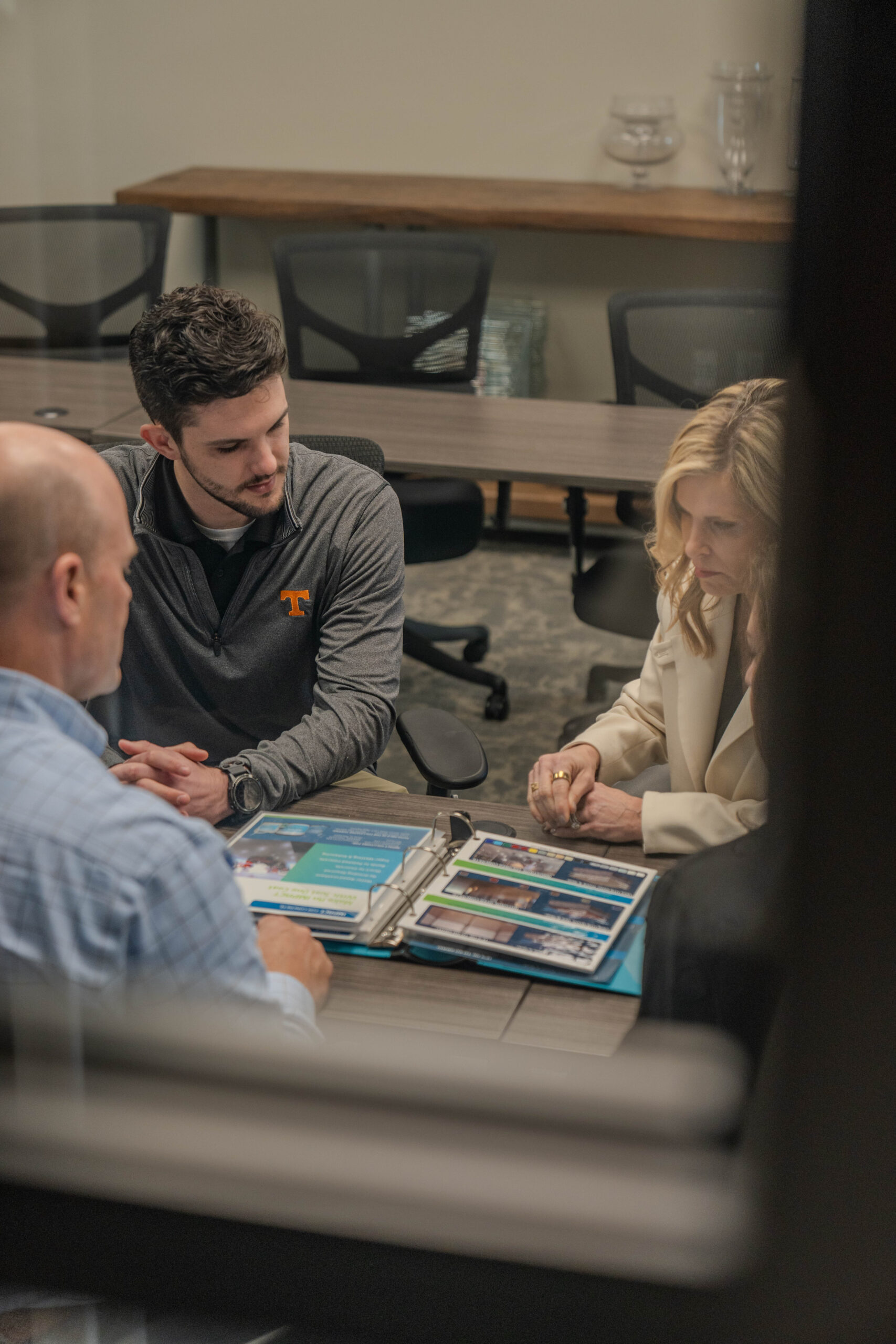 A group of people sitting at a table looking at a document and brainstorming. DPM Surface Care