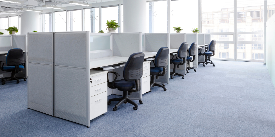 A row of cubicles with chairs in a commercial office, with carpet floor. DPM Surface Care