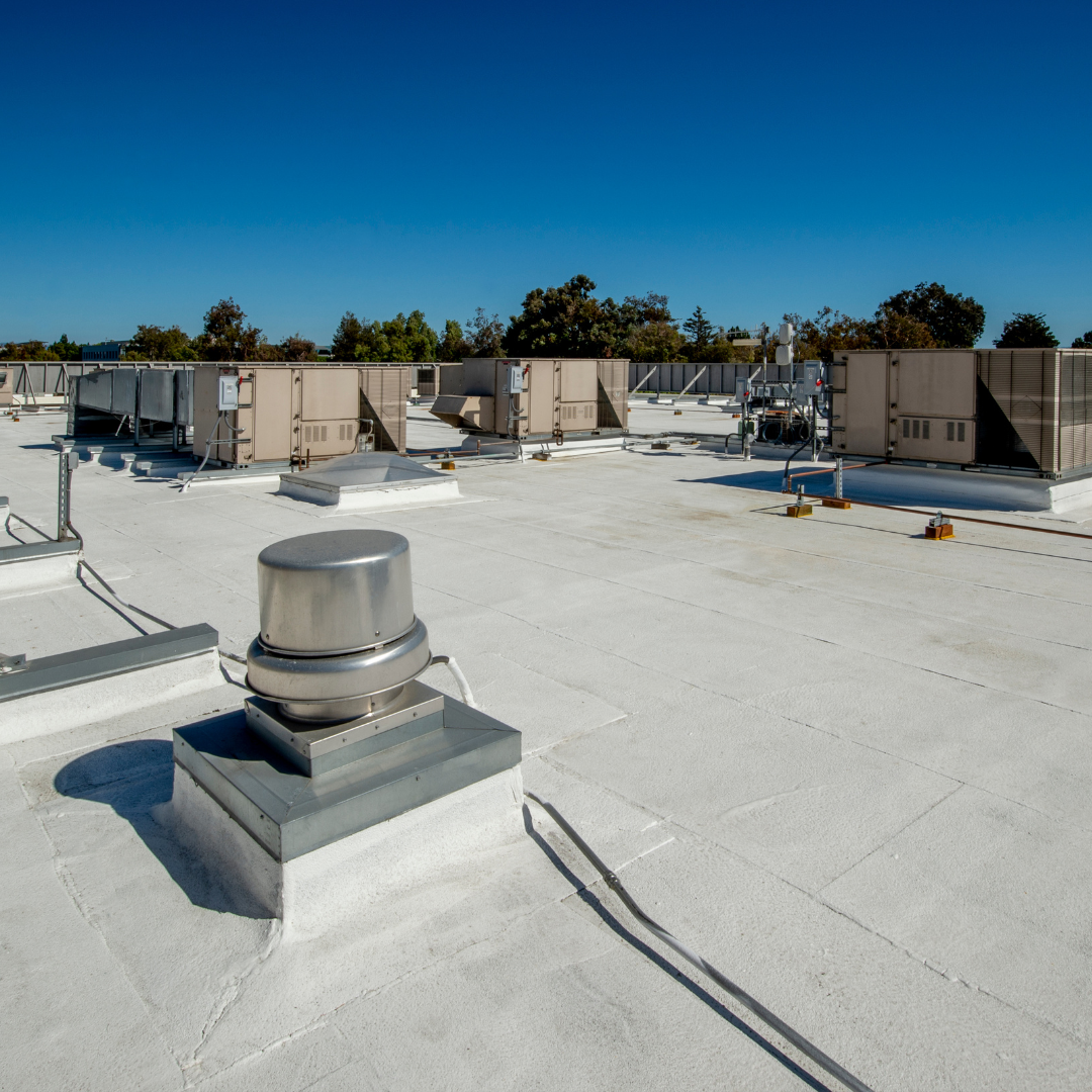A rooftop with air conditioning units and white concrete floor. Roof cleaning. DPM Surface Care