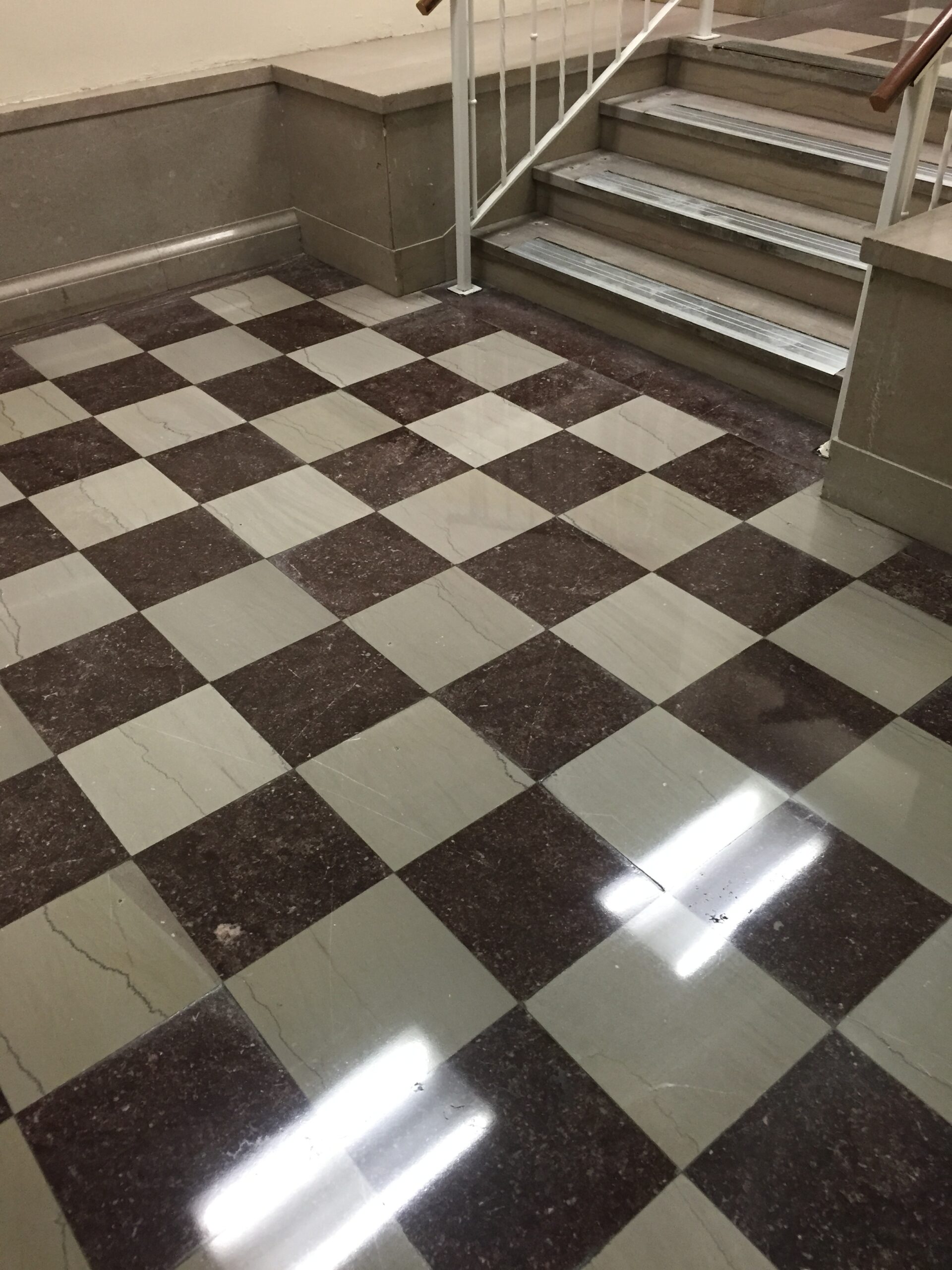 A cleaned and restored, tiled natural stone floor with a checkered pattern, after cleaning. DPM Surface Care