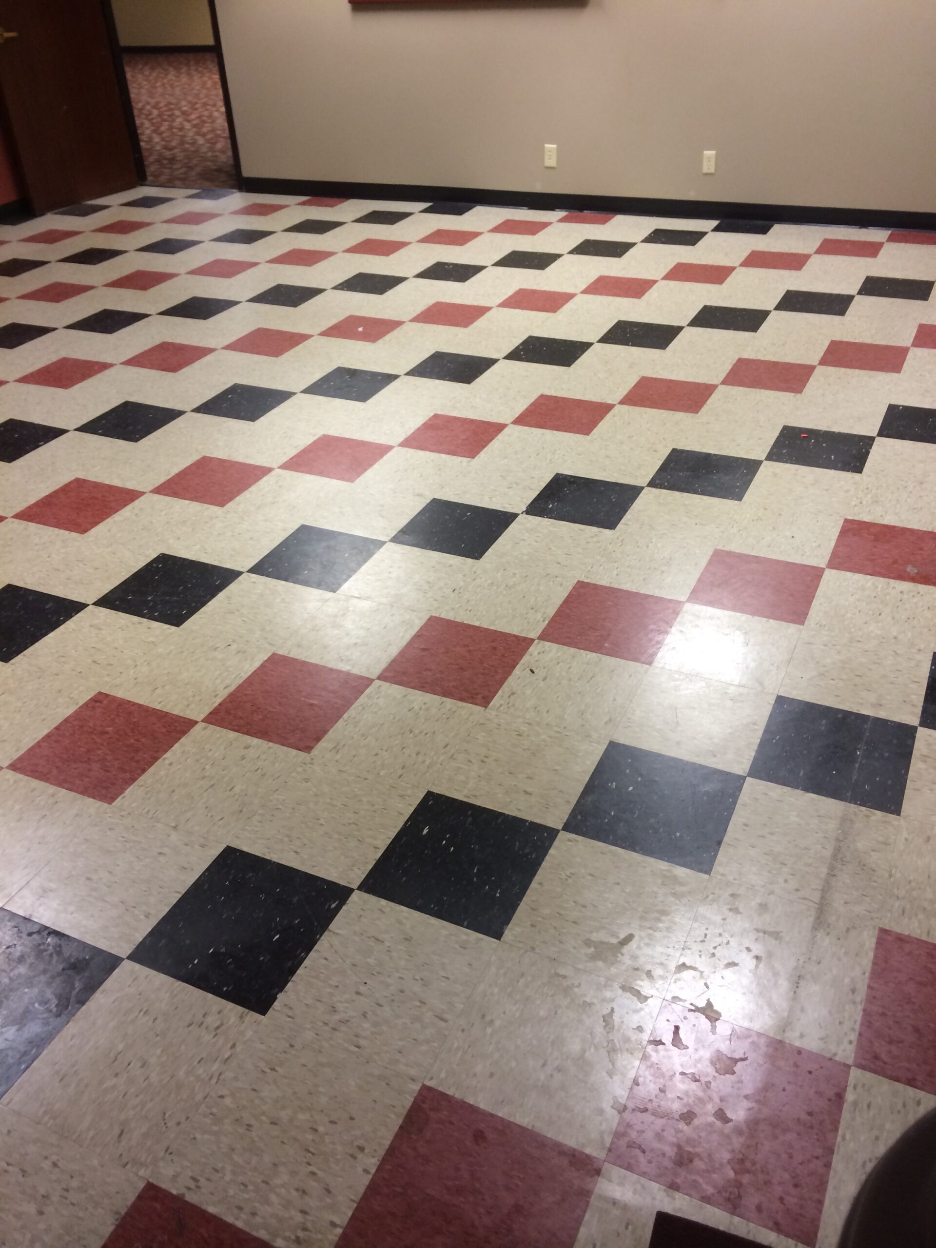 before – dry A tiled black and red checkered floor, worn out and faded. DPM Surface Care