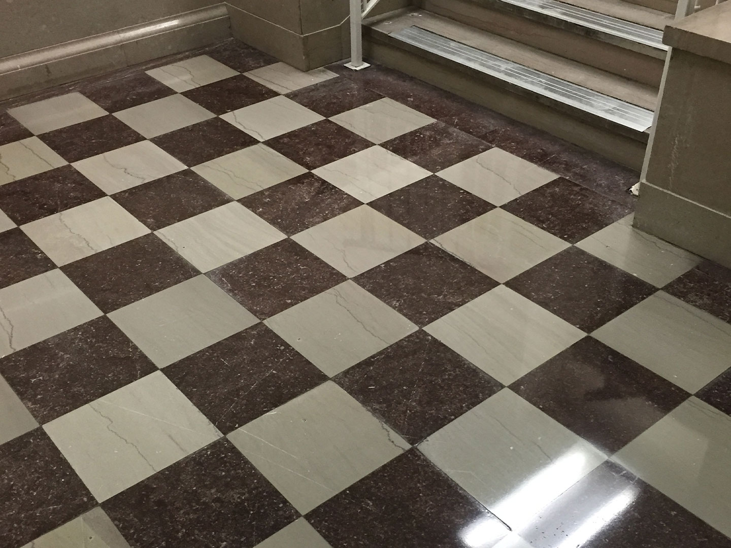 A cleaned and restored, tiled natural stone floor with a checkered pattern, after cleaning. Surface renewal. DPM Surface Care