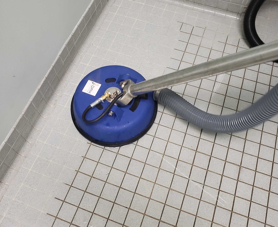 A vacuum cleaner cleaning a tile floor. DPM Surface Care