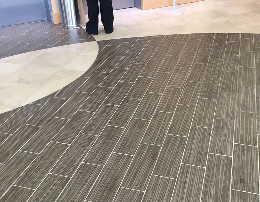 A combination of white and gray, clean tile flooring with cleaned grout in a commercial office. DPM Surface Care