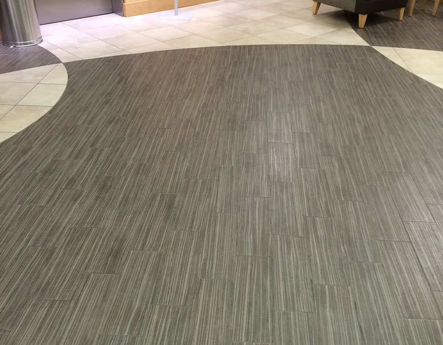 A combination of white and gray, clean tile flooring with cleaned grout in a commercial office. DPM Surface Care