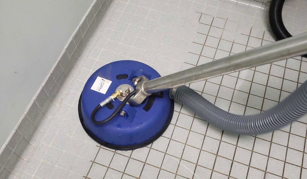 A vacuum cleaner cleaning a tile floor. DPM Surface Care